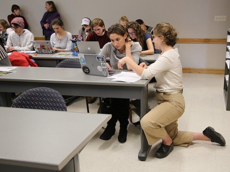 A student receives help from an aid.