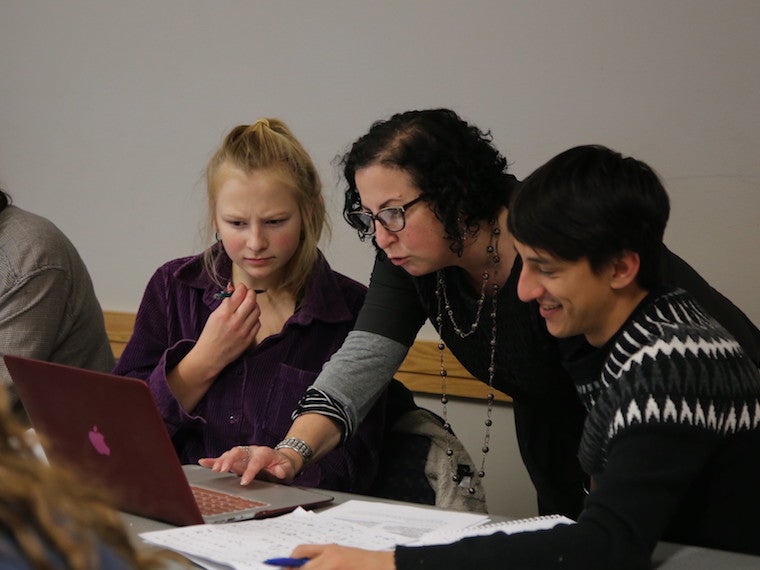 Students receive help from a teacher.