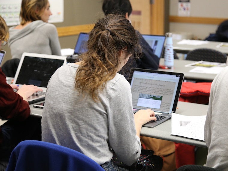 A students works at a laptop.