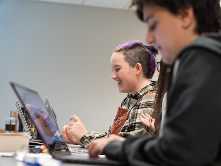 A student's reflection in a computer screen.
