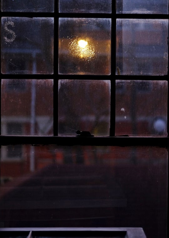 A window facing a brick wall.