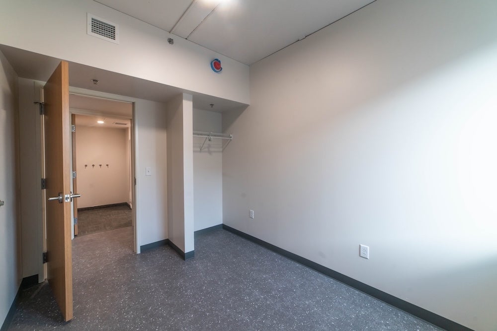 Photo of bedroom closet with door open showing the suite hallway