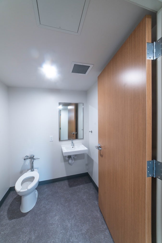 Photo of in-suite bathroom with sink, mirror, and toilet