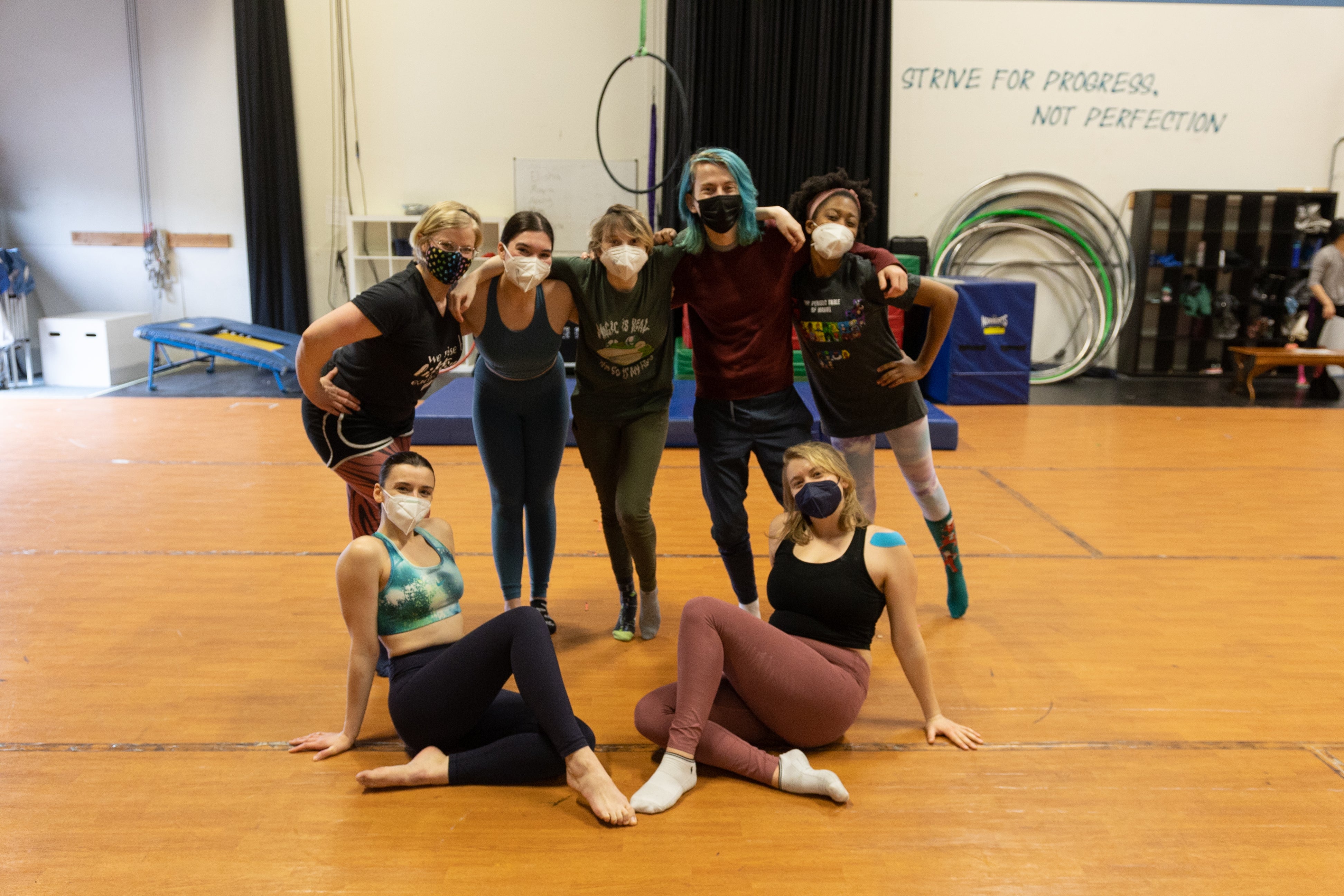Seven people pose for a picture inside the Seattle School of Acrobatics and New Circus Arts.