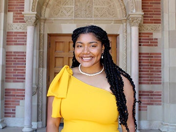 A student by a brick wall.