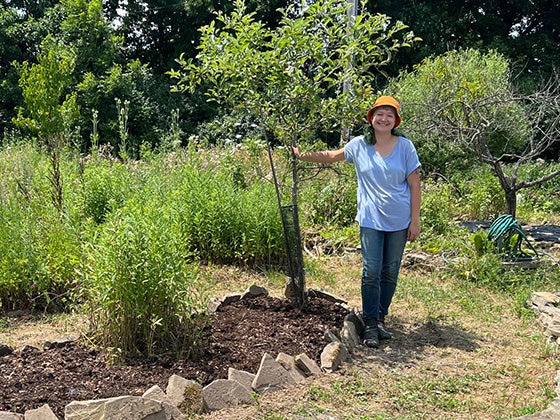 Amanda proudly shows a sapling she has planted.