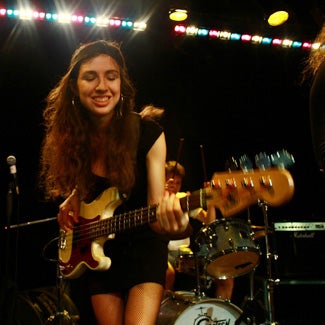 Arianna playing electric bass on stage