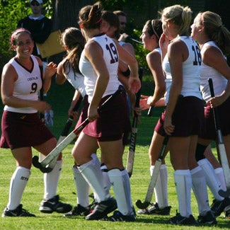 Field hockey players gather during a break in the action