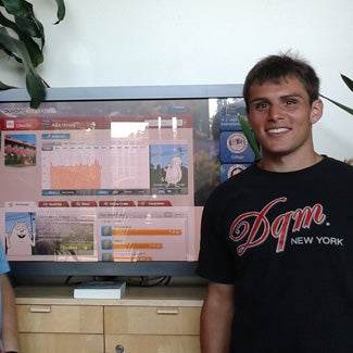 Evan beside a video monitor showing environmental data