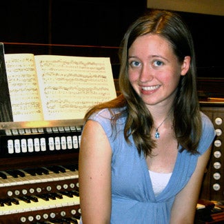 Young woman seated by an organ keyboard