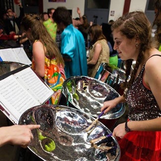 Maya reads sheet music while practicing on steel drums.