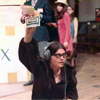 Woman wearing headphones and microphone on a production set.