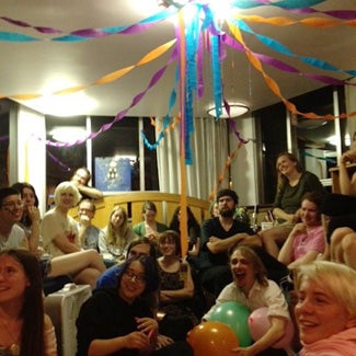 People at a party with streamers and balloons.