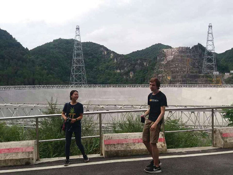 Students walking in front of dish