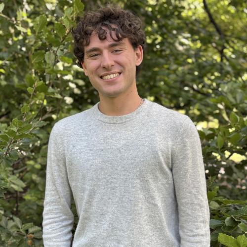 A male Oberlin student in a gray shirt, standing outside.