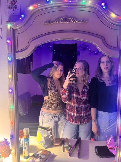 Natalie and friends posing before a multi-colored mirror in getting ready