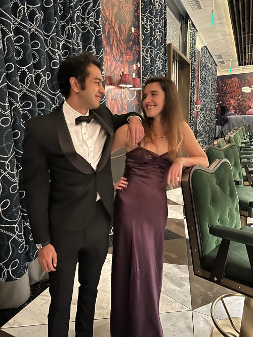 Aahil in a tuxedo smiling at Ava in a dress