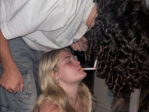 Aidan lighting Grace's cigarette with theirs