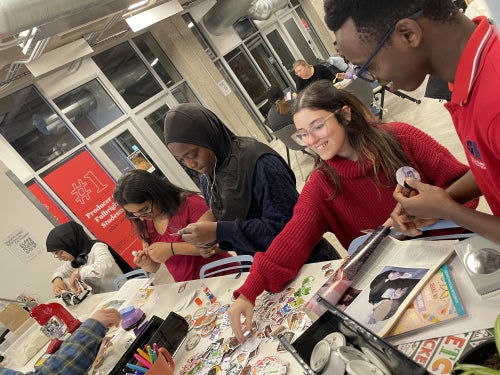 Scholars make pins and buttons before a STRONG dinner in CELA