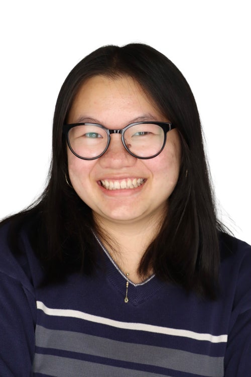 a person with glasses and a dark blue shirt with gray and white stripes