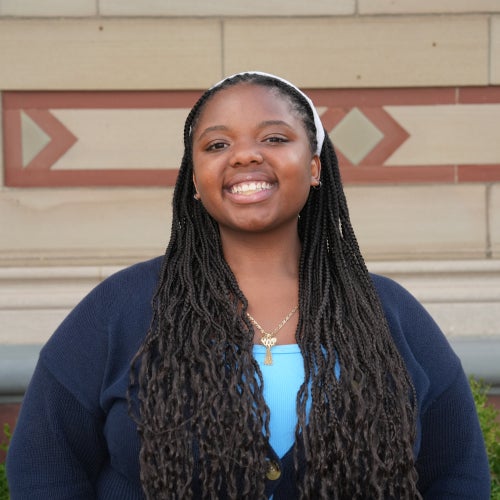 A headshot of a female student with long dark hair in a blue shirt.