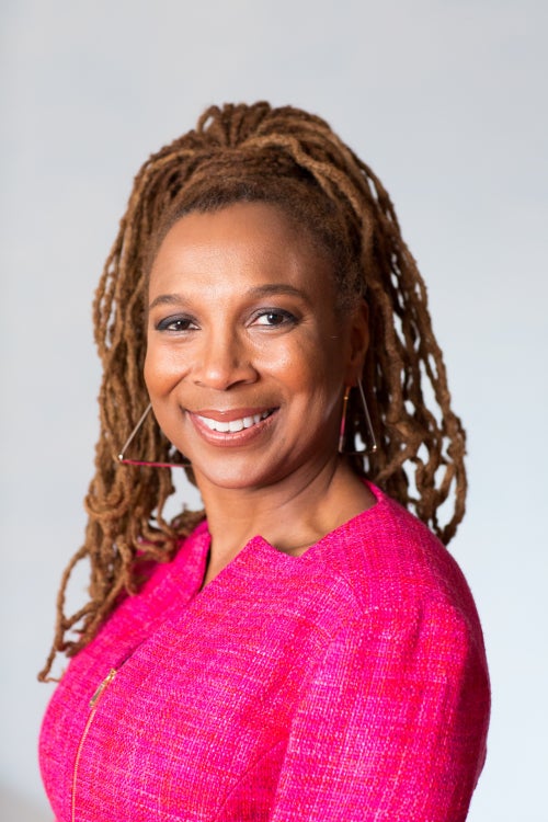 A Headshot of activist Kimberle W. Crenshaw. She has her hair up and is wearing a pink top.