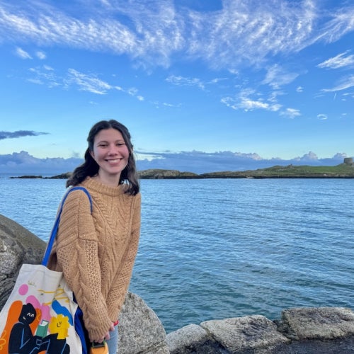 Girl smiling in front of a large body of water