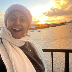 Aishwarya smiling with a beautiful scenic sunset behind in Hamburg, Germany