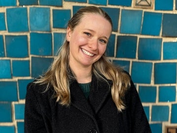 Person smiles at camera wtih blue tiles in background