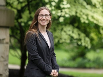 Student smiles at camera outdoors
