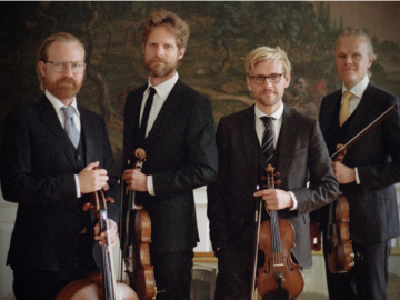 four men, standing together, holding string instruments