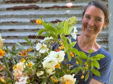 a person smiles behind a bouquet of flowers
