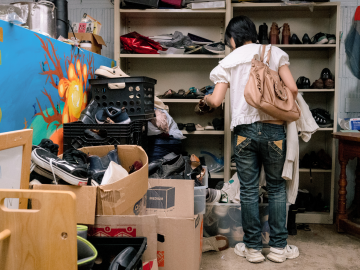 a student looks through a room full of clothing and ephemera