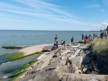 a group of students on rocks on a lake