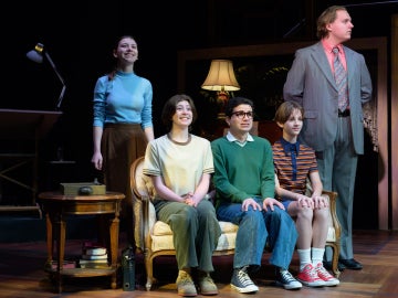 the cast of fun home sitting on a couch onstage