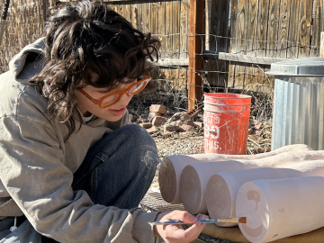 student painting pottery