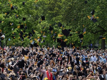 new graduates throwing mortarboards into the air.