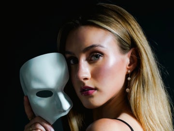 a person holding a phantom mask next to their head