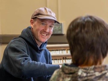 Ian Page cheerfully talking to a student.