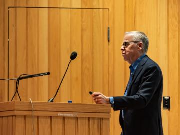 A man talks at a podium.