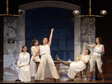 Five suffragists from Suffs pose on stage