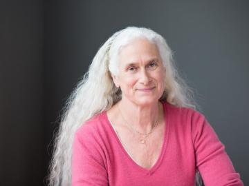 woman posing for portrait with pinck shirt and long white hair