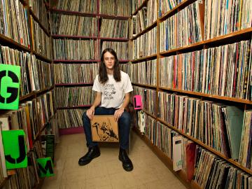 Adrian Rew ’13 surrounded by shelves full of LP records