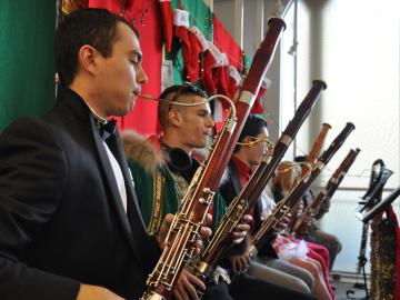 Bassoonists seated under a row of Christmas stockings