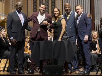 Chris Jenkins is pictured on the Severance Hall concert stage with four people gathered for the award presentation