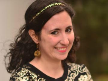 A woman smiles with arms folded