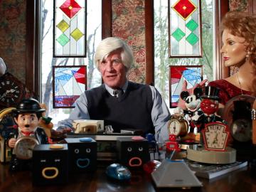 McKinly surronded by his collection of unusual clocks.