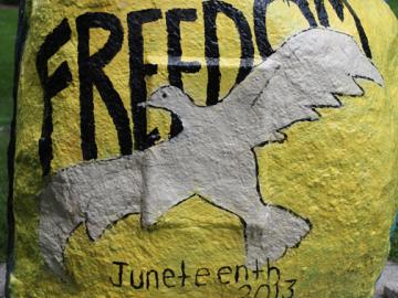 A rock painted with a dove and the words "Freedom Juneteenth 2013"