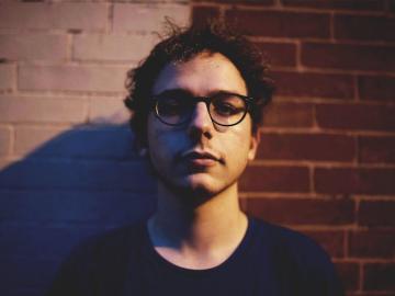 Headshot of Griffin Jennings against a brick wall 