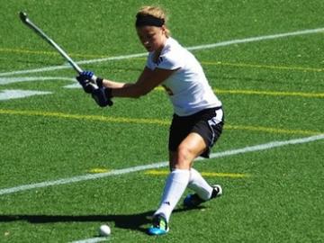A field hockey athlete goes after the ball.